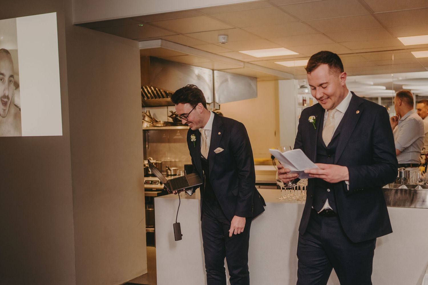 Wedding guests in a venue basement preparing speeches or toasts.