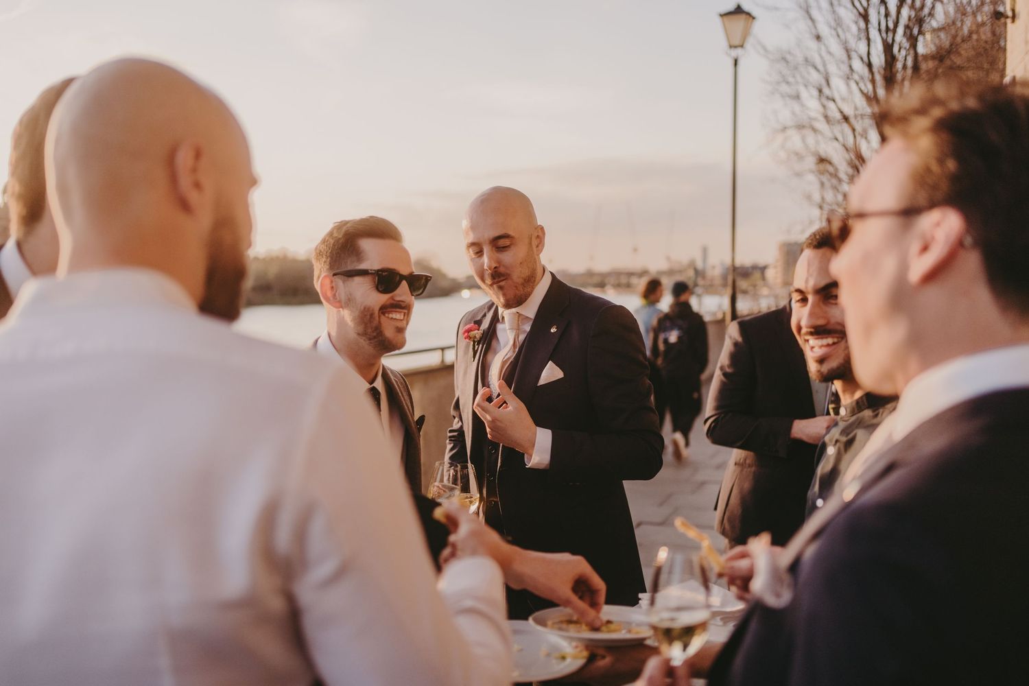 Wedding guests socializing and enjoying drinks at outdoor celebration.