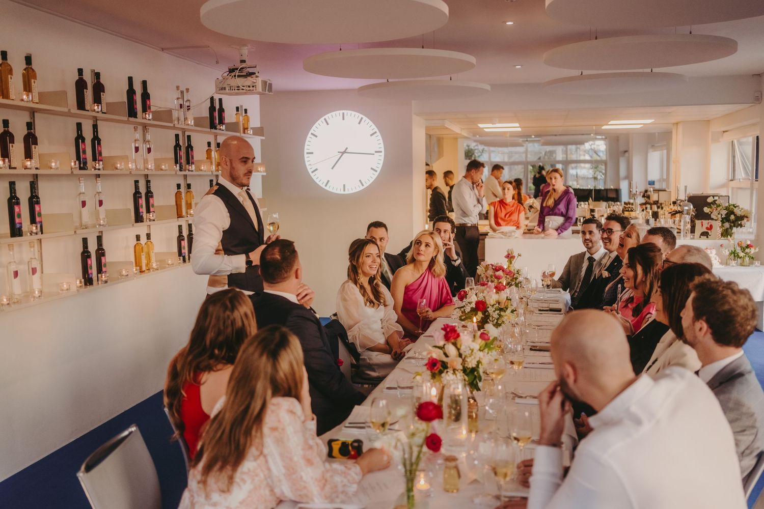 Elegant dining room with pink ambient lighting and extensive wine bottle display wall.