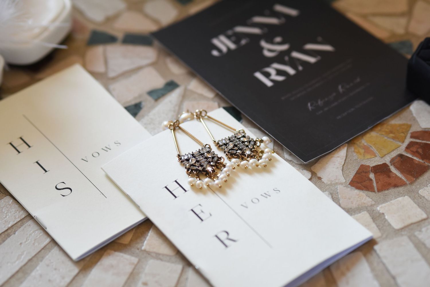 Modern black and white wedding stationery displayed on marble surface.