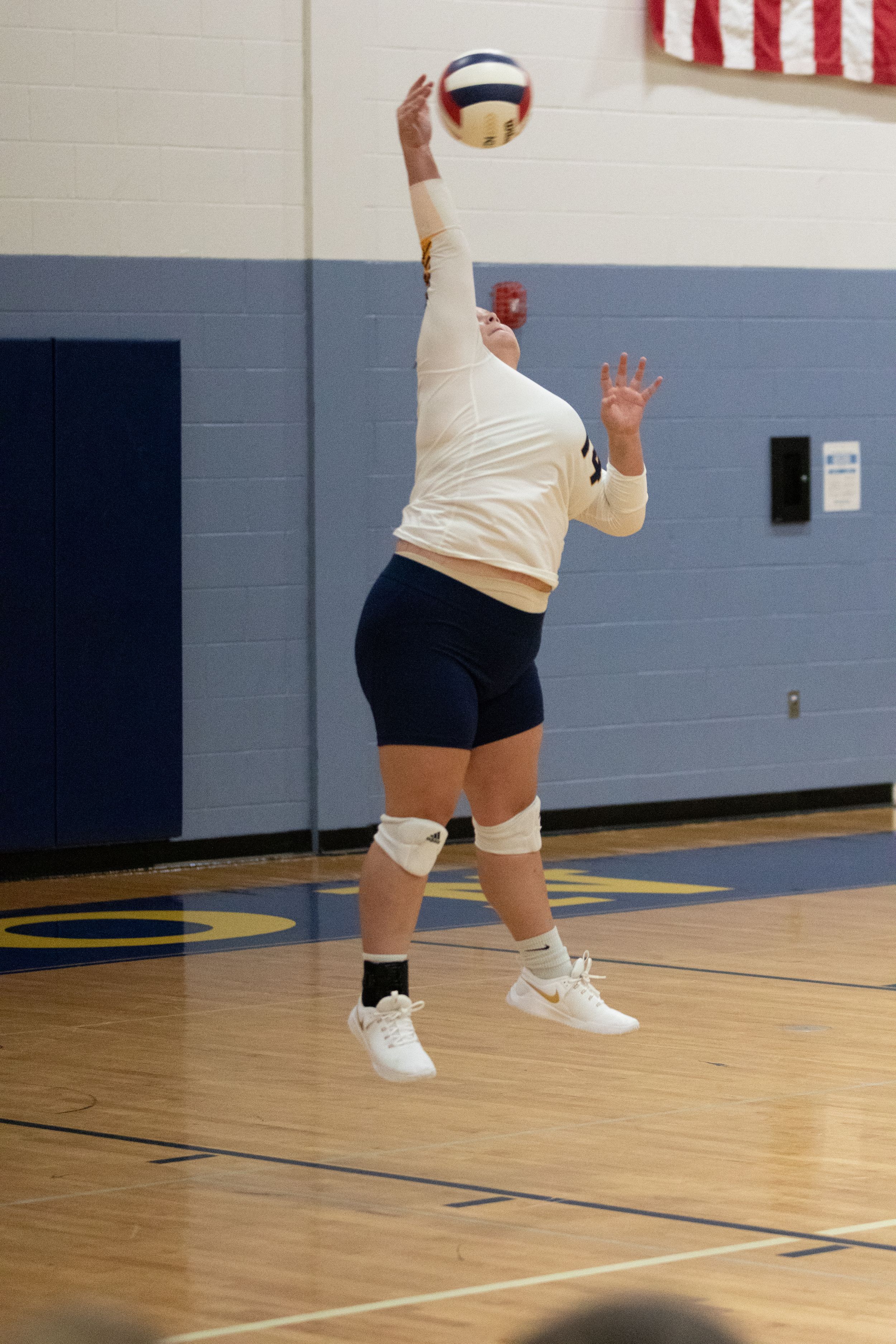 Photograph of Buffalo High School Volleyball player jump serving.