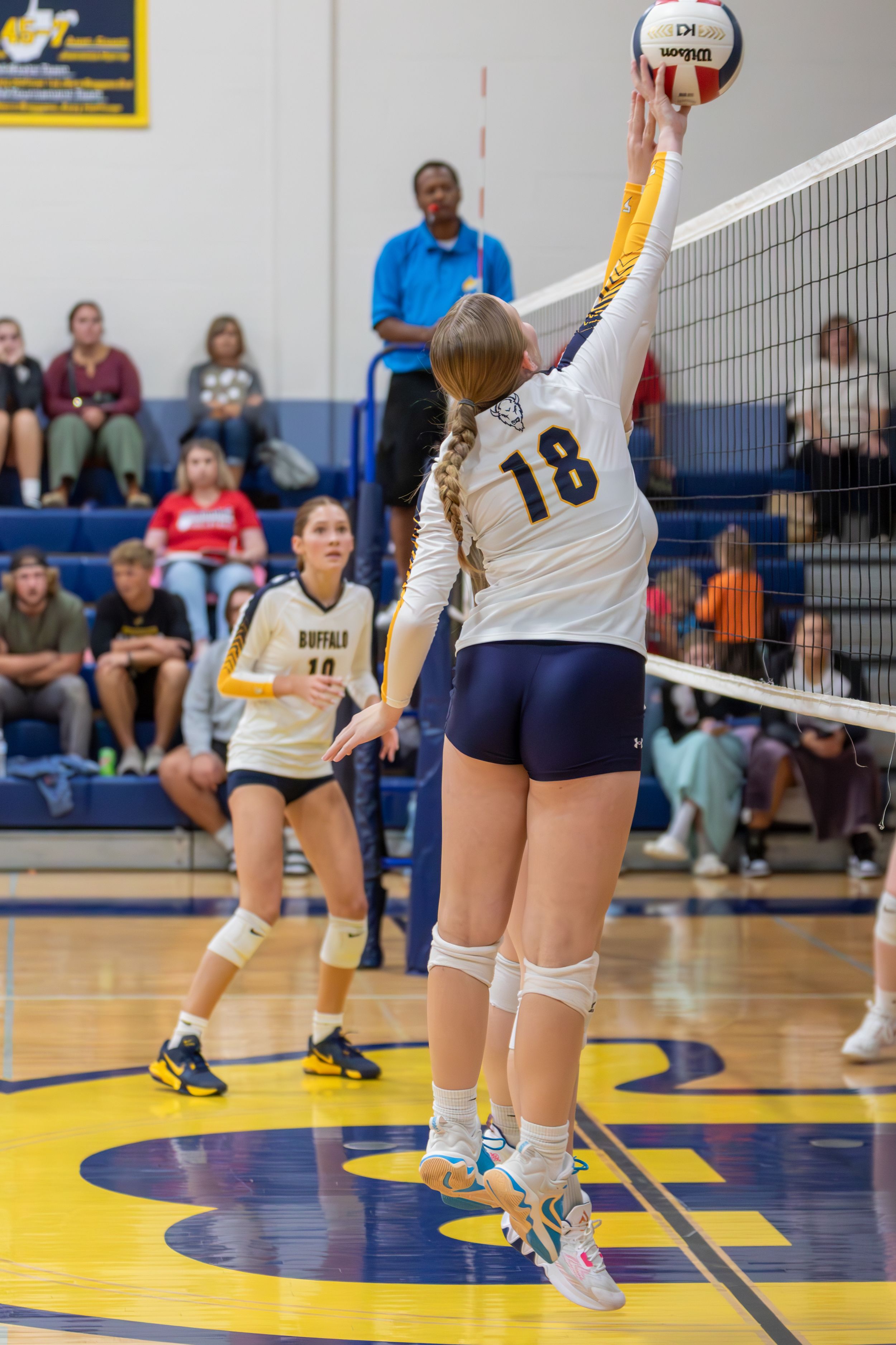 Photograph of Buffalo High School volleyball player blocking the ball.