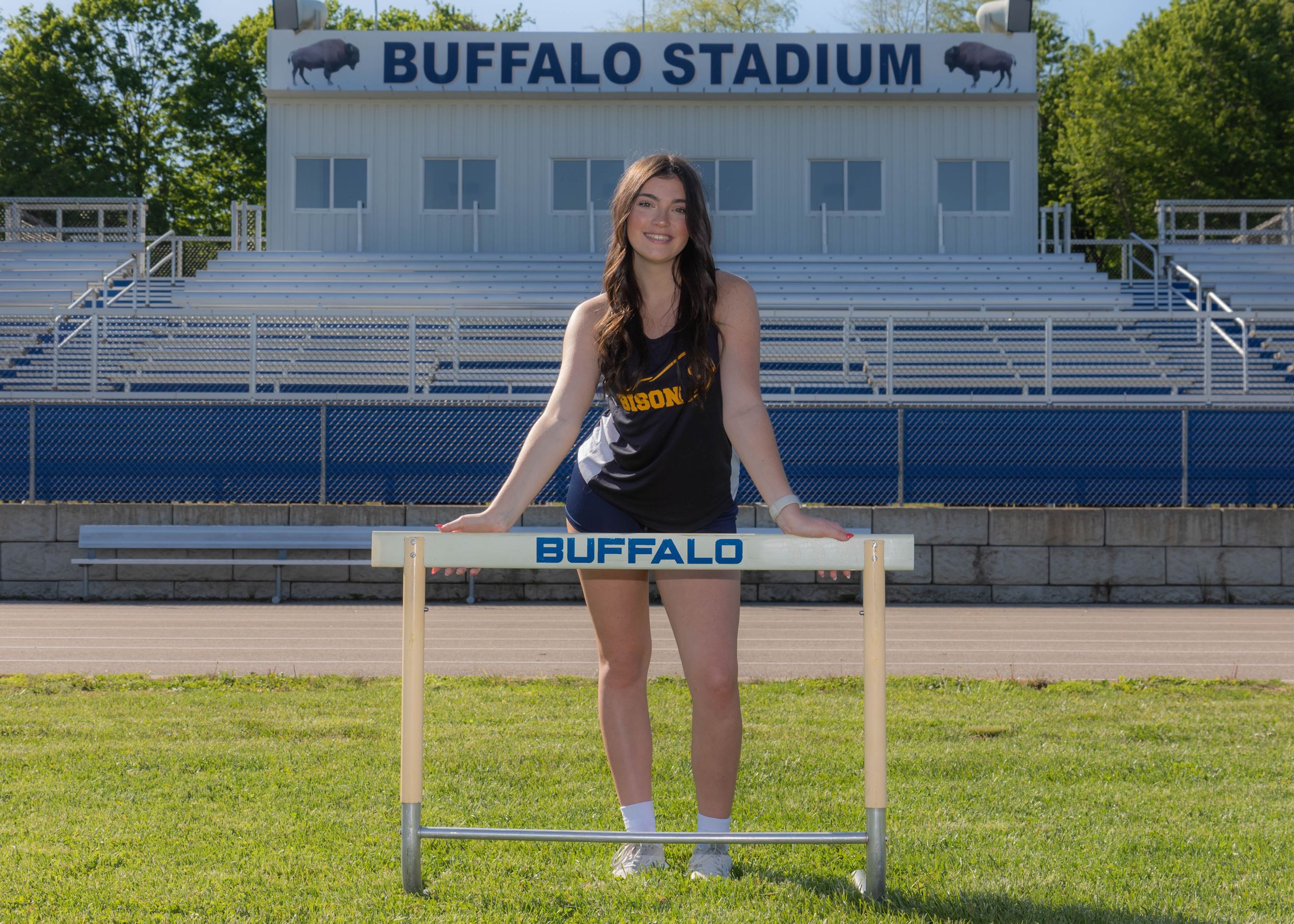 Team Sports Photograph of Audrey Downey posing with a hurdle at the Buffalo High School Track and Field.