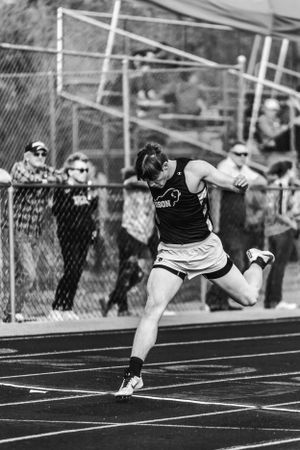 Photograph of Bradley Harris crossing the finish line for Buffalo High School at a Winfield High School Track meet.