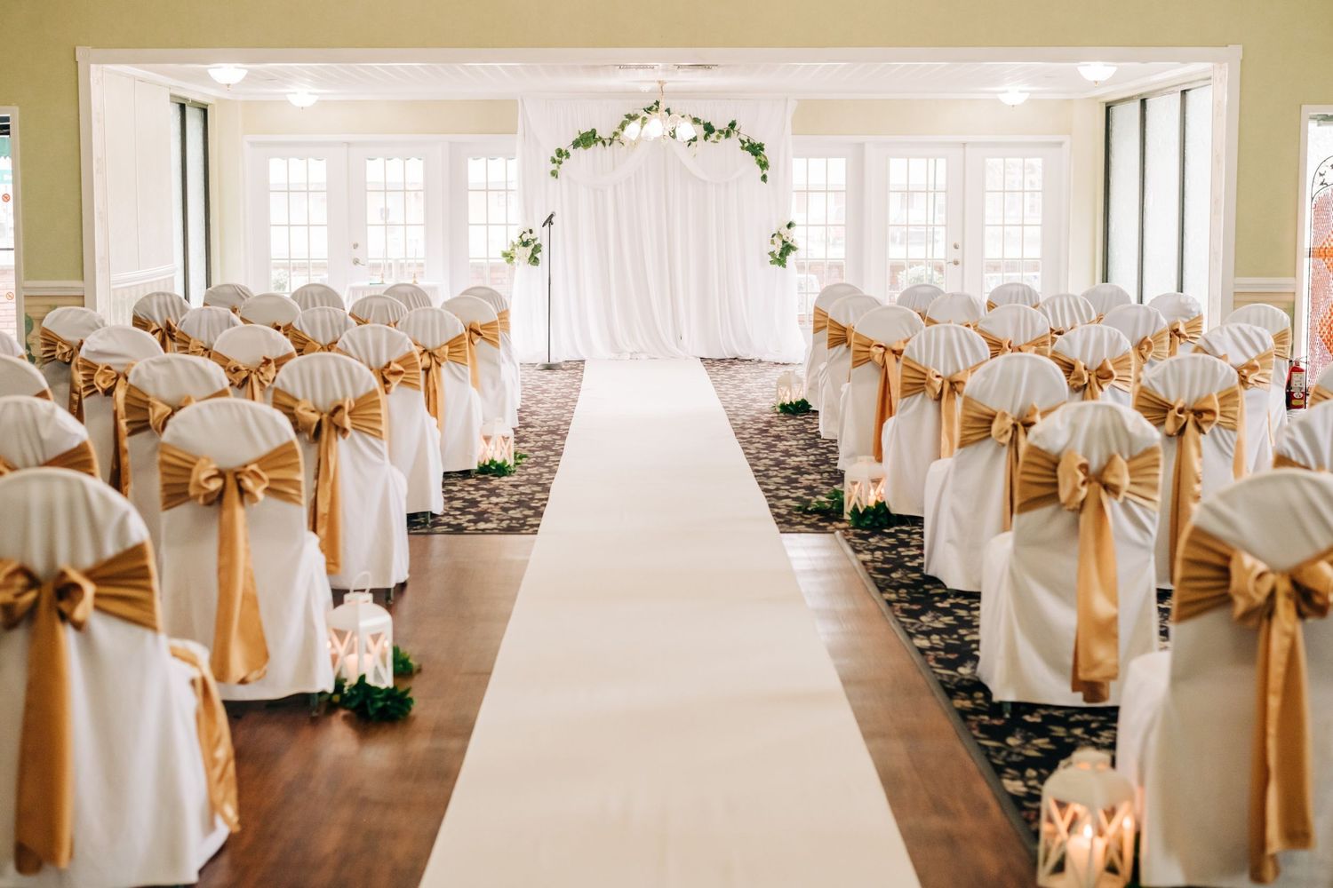 wedding ceremony venue, white chairs with gold satin ribbon
