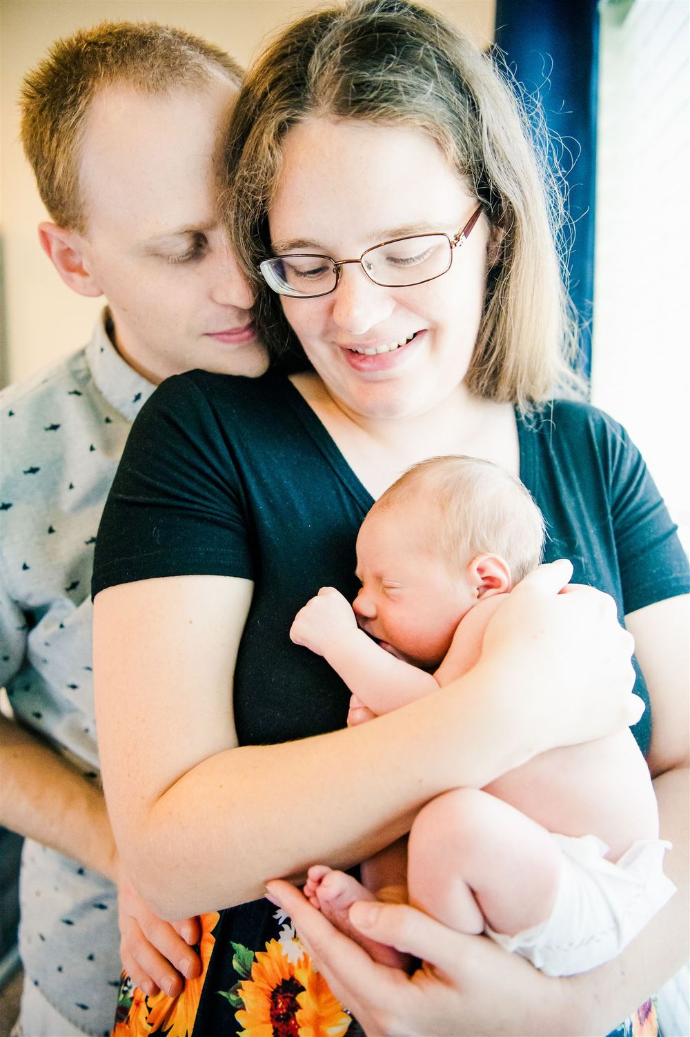 New parents sharing intimate moment with newborn baby.