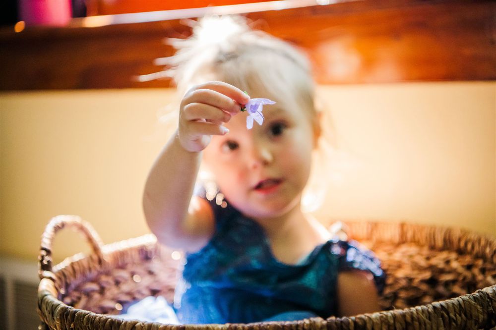 Child playing with star decoration in woven basket.