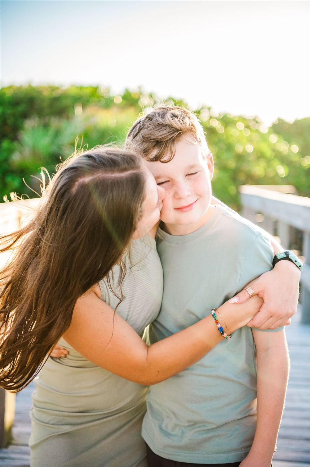 A tender moment between two people sharing an embrace on a wooden deck.