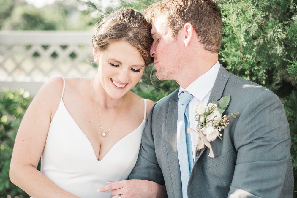 A couple sharing a joyful moment during their wedding day in an outdoor garden setting.