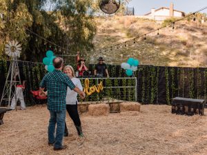 Outdoor event space decorated with teal balloons and string lights against a natural desert landscape.