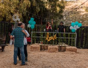 Desert venue decorated with teal balloons and 'love' signage for an outdoor celebration.