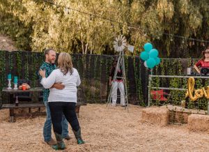 Outdoor desert venue with teal and white balloons and string light decorations for a celebration.