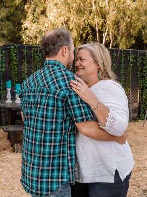 Tender embrace captured in natural outdoor setting with decorative elements and soft lighting.