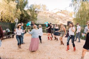 Guests enjoying themselves at a casual outdoor party with decorative lighting and desert surroundings.
