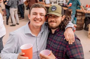 Friends enjoying drinks and conversation at a casual outdoor gathering.
