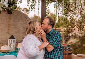 Celebratory moment captured under a rustic wooden pergola during an outdoor event.