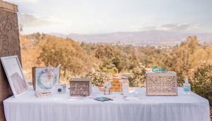 Wedding reception setup with tables and decor against a desert mountain backdrop.