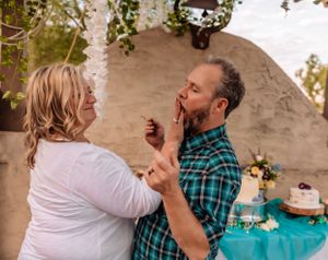 Close interaction between party guests under a decorated pergola with teal draping.
