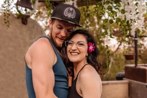 Intimate couple moment captured under hanging greenery and turquoise drapes.