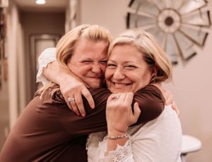 Emotional embraces captured in sepia tones in an indoor setting.