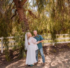 Sweet interactions captured under weeping willow trees in outdoor setting.
