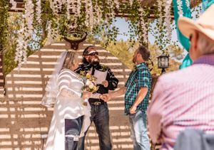 Outdoor wedding ceremony space with hanging floral arrangements and turquoise accents.