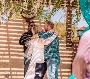 Outdoor wedding celebration with natural lighting and turquoise decorative elements.