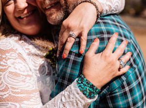 Close-up shot showing hands and a turquoise plaid shirt during an intimate moment.