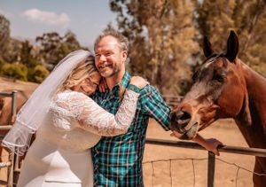 A couple shares tender moments with their horse during an outdoor wedding photoshoot.