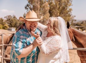 A country-style wedding shoot with a couple and their horse against a natural backdrop.