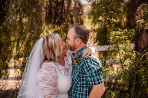 Romantic outdoor portraits under trees during a rustic wedding celebration.