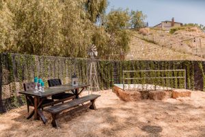 Panoramic view of a desert wedding venue with rustic stone walls and natural landscaping.