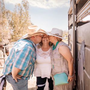 Group photo session in a rustic outdoor setting with casual western-themed attire.