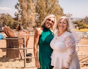 Outdoor celebration with people in white lace and casual attire against a desert backdrop.