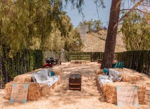 Desert landscape with willow trees and stone retaining walls creating an outdoor venue space.
