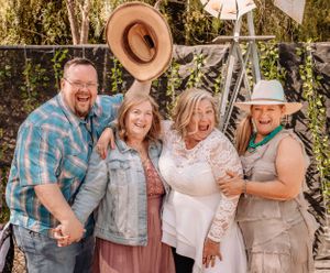 Friends in rustic attire and cowboy hats pose together for casual outdoor portraits.