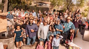 Panoramic view of crowd gathering at outdoor western-themed celebration.
