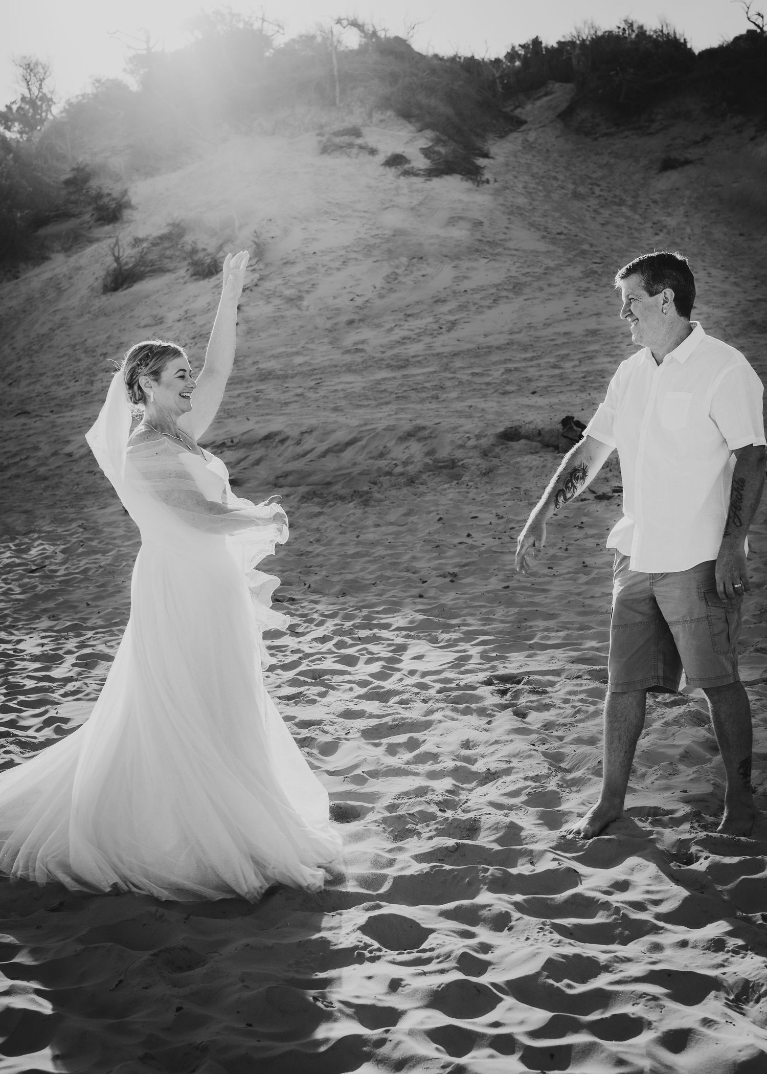 A beautiful newlywed couple dancing atop Carlo Sandblow at Rainbow Beach, Queensland on their wedding day