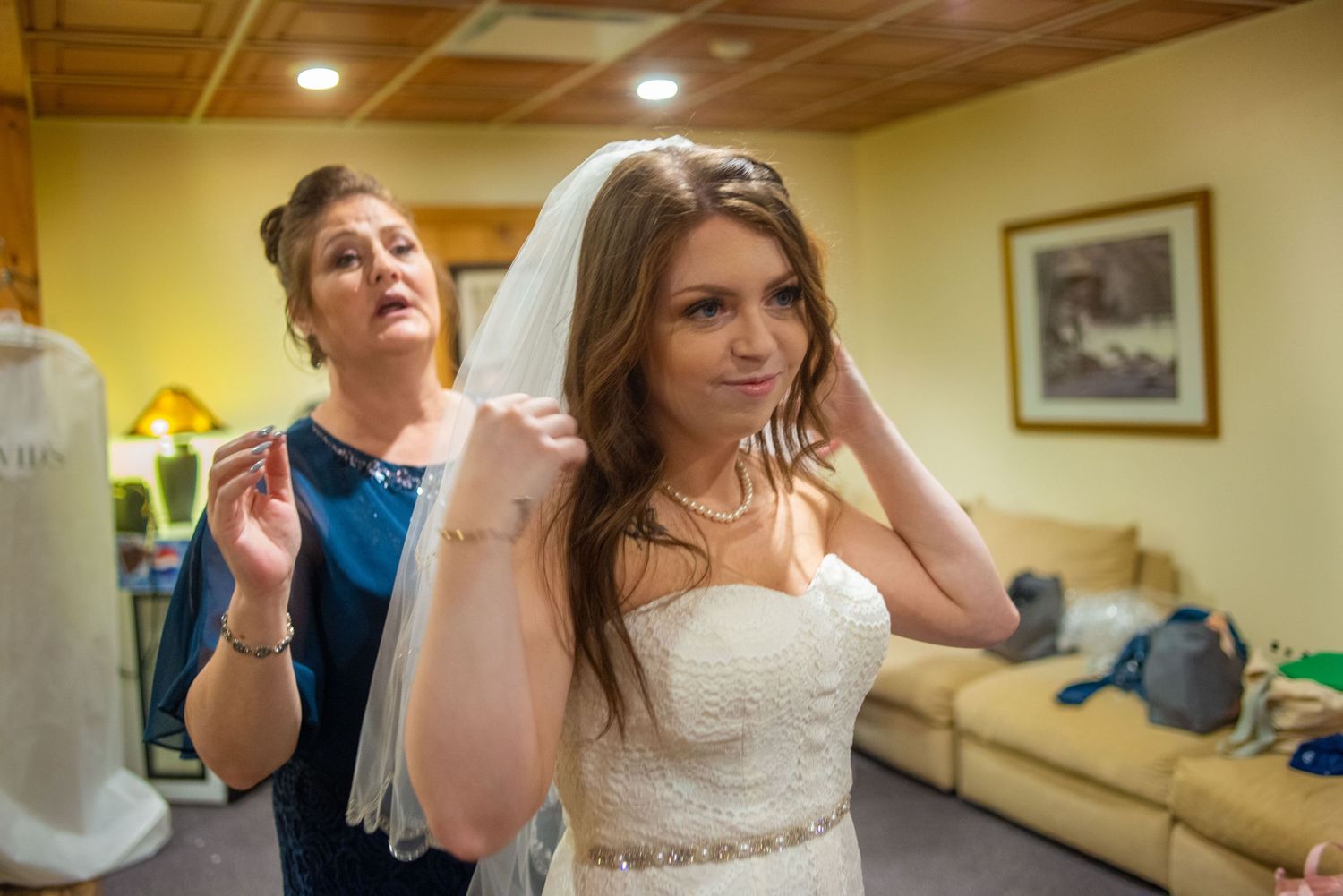Candid moment of bride getting ready with hair and jewelry preparations.
