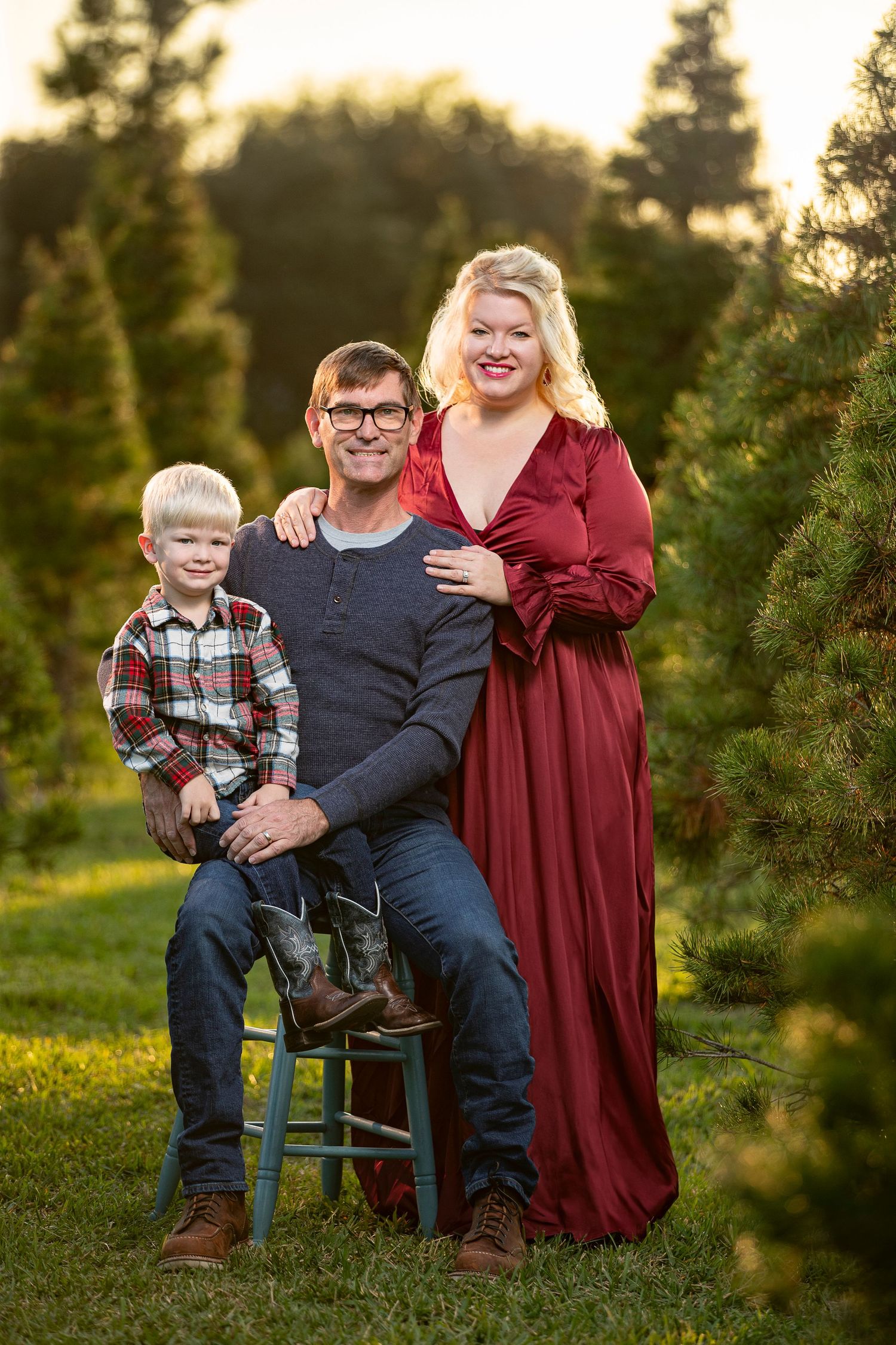 Family portrait at Christmas tree farm during golden hour.