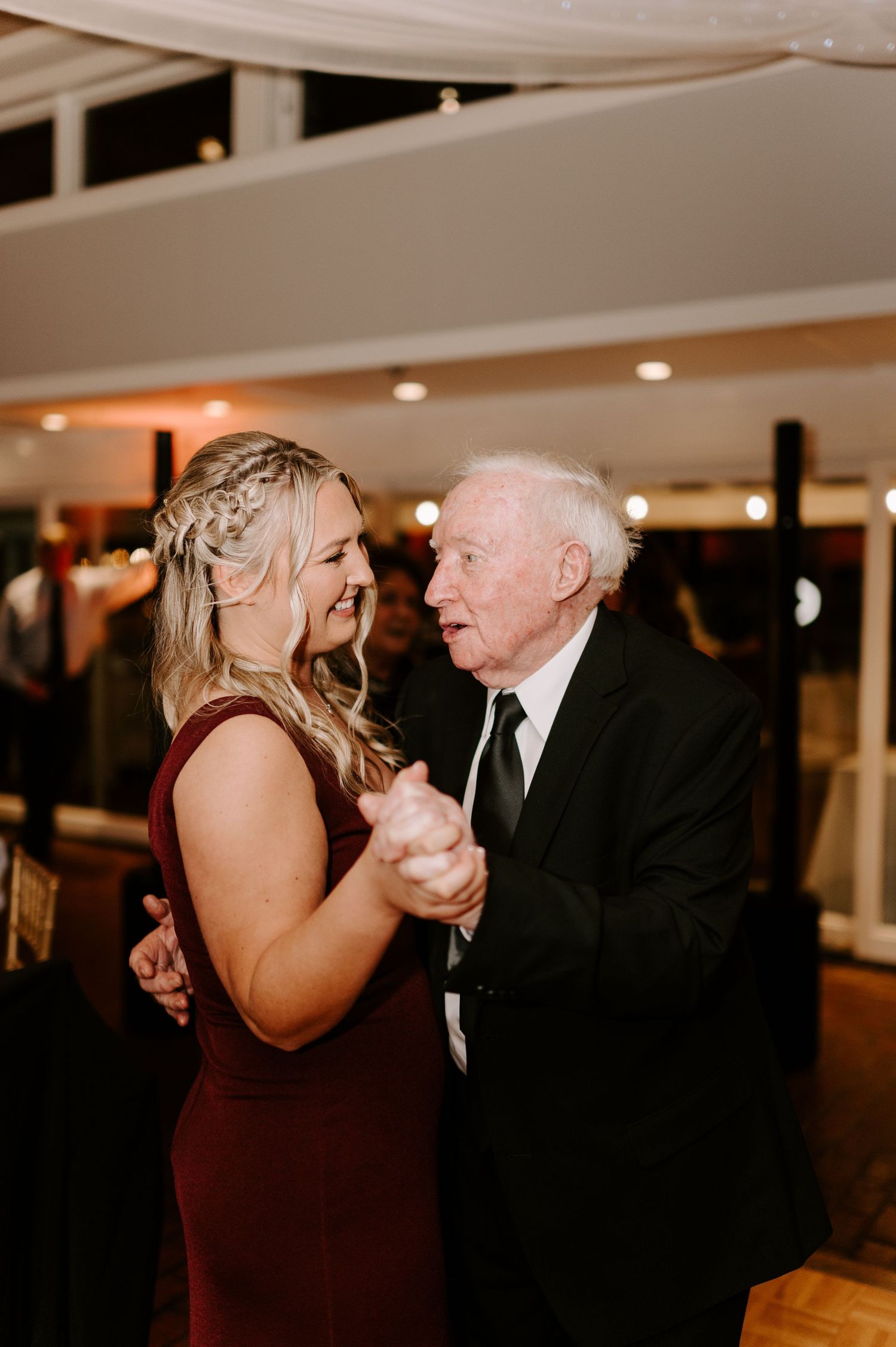 Heartwarming dance moment between two generations at an elegant wedding reception.