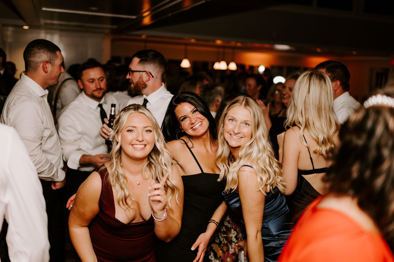 Joyful guests celebrating and dancing at a lively wedding reception party.