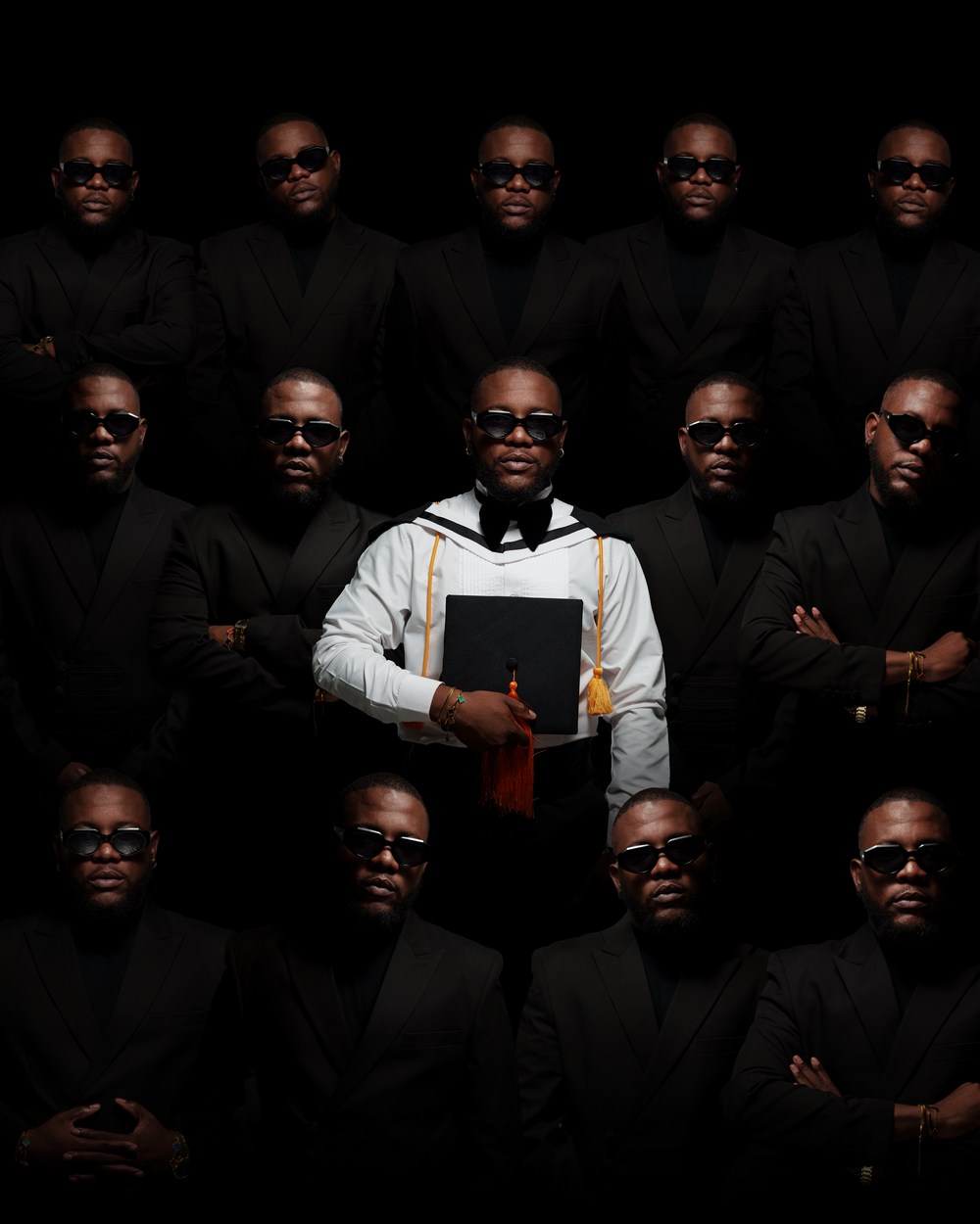 Creative portrait of people in dark suits and sunglasses arranged in rows with one person in light hoodie.