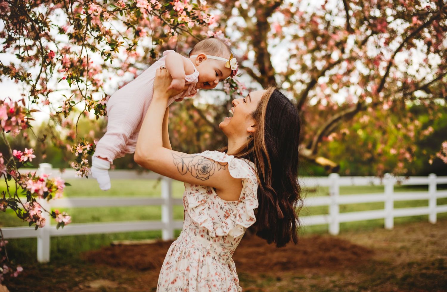 Laughing baby in New Haven, CT with mother in flowery trees