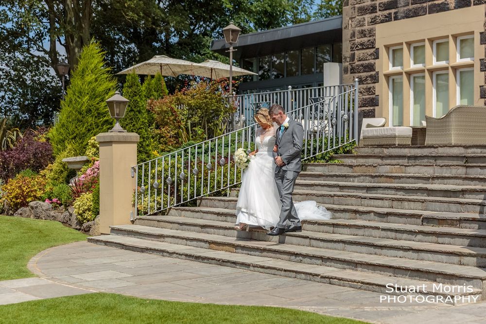 Bride and her dad walk down the steps to the gardens at west tower hotel Aughton ormskirk.