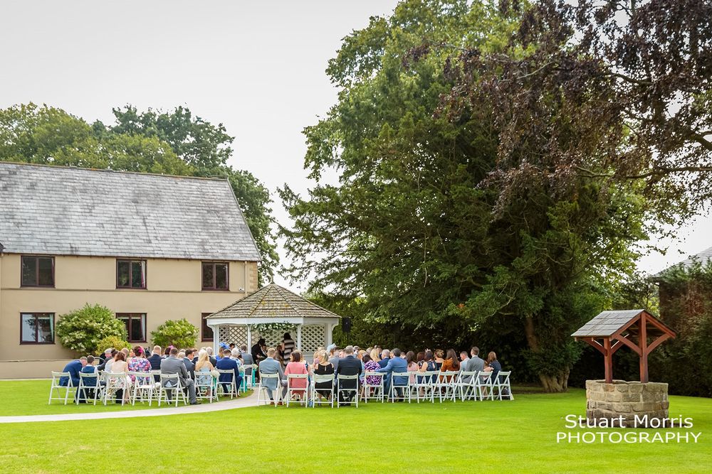 Wide shot from the back of the outdoor wedding ceremony at west tower country house. Lancashire wedding photography.