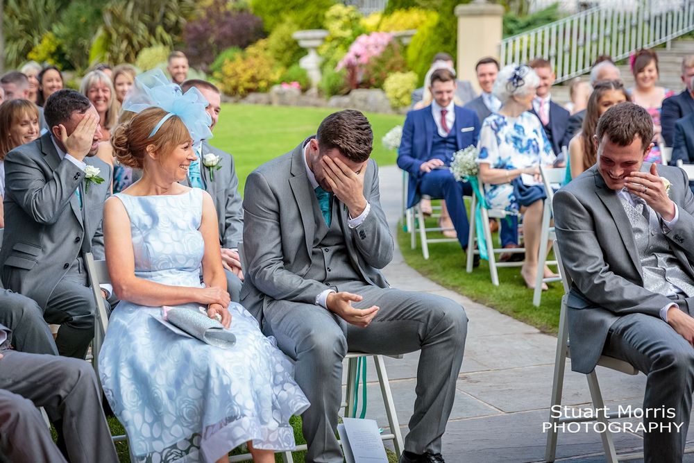 Best man with his head in his hand during the outdoor west tower wedding ceremony.  Lancashire wedding photographer