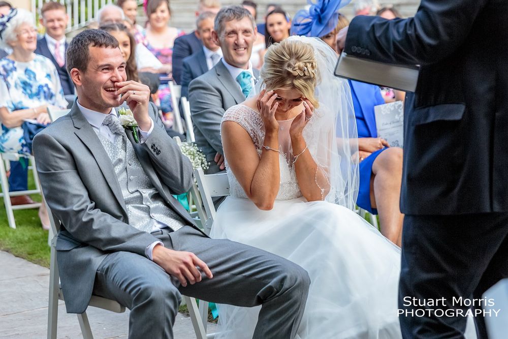 Bride and groom laughing during the outdoor ceremony. West tower wedding photographer. Lancashire wedding venue.