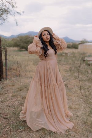 A flowy peach dress with tiered ruffles creates movement in a desert setting.