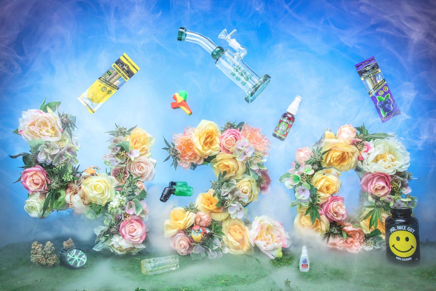 Colorful 420 floral arrangement with cannabis accessories and bongs on blue background.